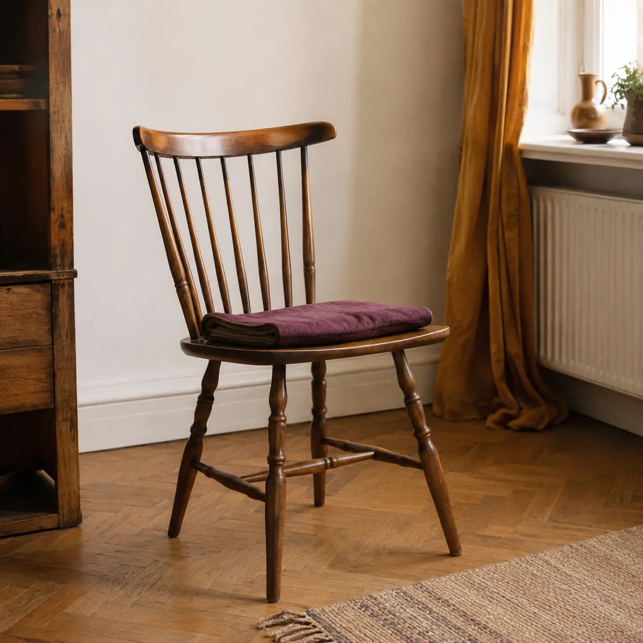 Une chaise en bois avec un coussin prune dans un appartement lumineux.